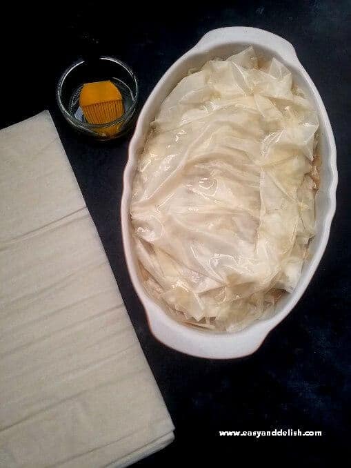 An easy Mediterranean Chicken Pot Pie made with phyllo dough. It is lighter but has all the comforting flavors of the classic dish yet with a Mediterranean touch! Oiling phyllo dough sheets for topping of Mediterranean chicken pot pie