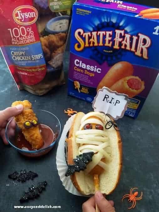 Mummy coffin corn dogs and "bloody chunky worm" on a table