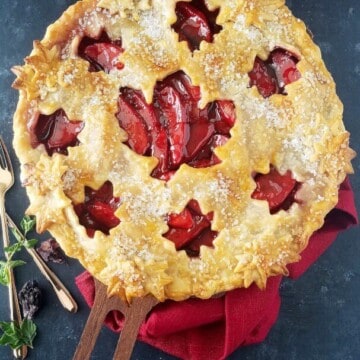 A close up of  baked apple pie with forks on the side