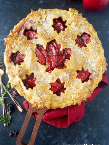 A close up of  baked apple pie with forks on the side