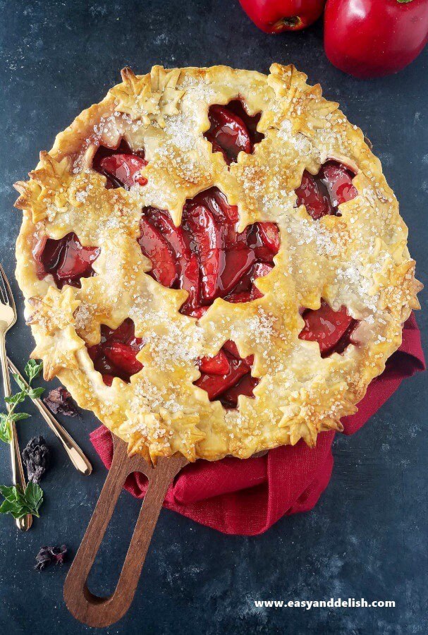 A close up of baked apple pie with forks on the side