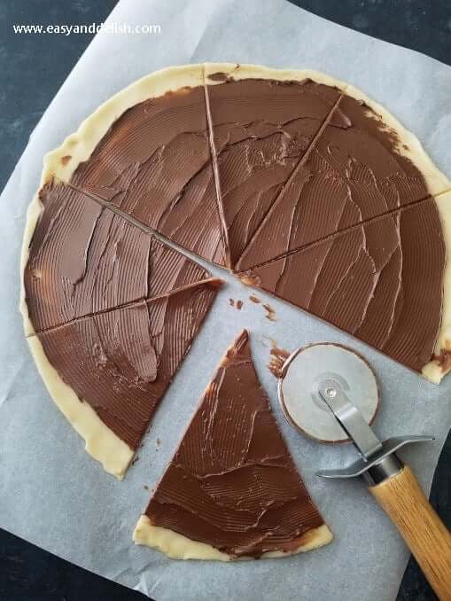 pie crust with Chocolate Hazelnut Spread spread being cut to make Nutella cookie roll ups