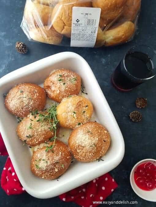 Baked yeast dinner rolls baked with Parm cheese and hers in a baking dish