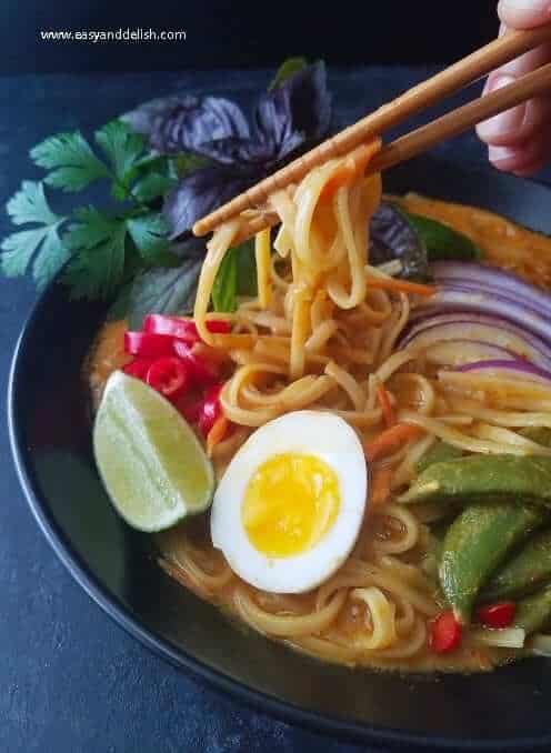 Noodles from one pot coconut noodle soup being picked up in a mound with chopsticks