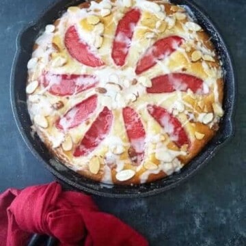 A skillet of almond cake with a napkin