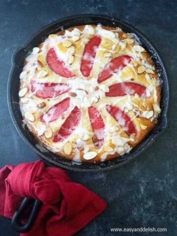 A skillet of almond cake with a napkin