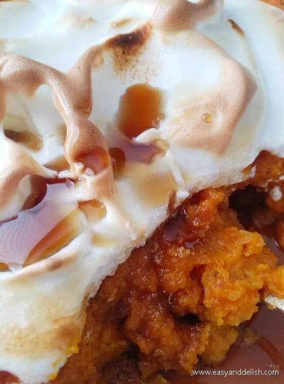 close up image of make-ahead sweet potato casserole sliced with a maple syrup drizzle