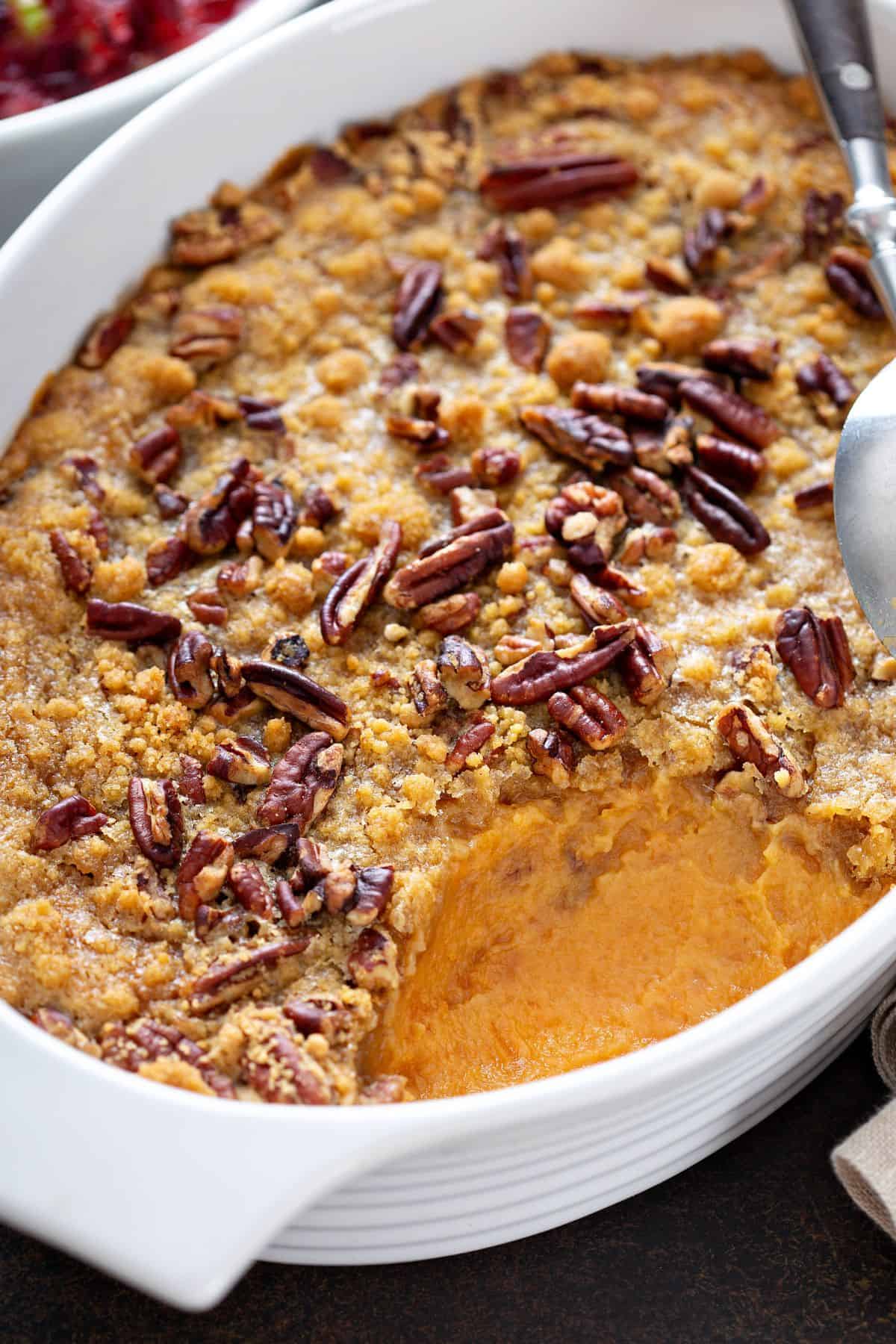 sweet potato casserole with pecans in a baking dish.