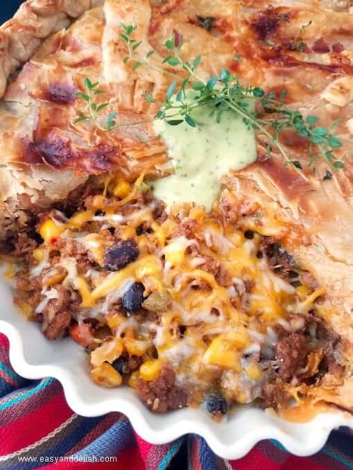 Close up image of chili bean turkey pot pie topped with guacamole sauce