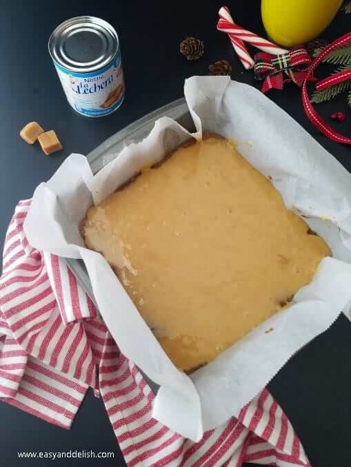 Brazilian-Style Gingerbread Cookie Bars are made from gingerbread cookie dough filled with a thin layer of dulce de leche and topped with chocolate ganache. layering filling into pan