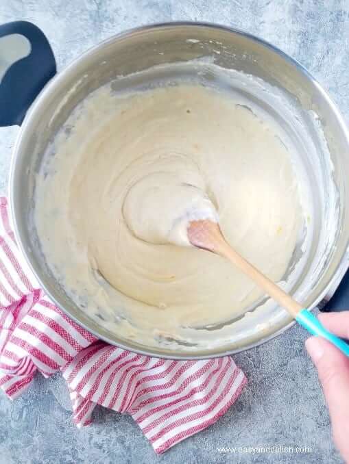 stirring cheese sauce in a pan