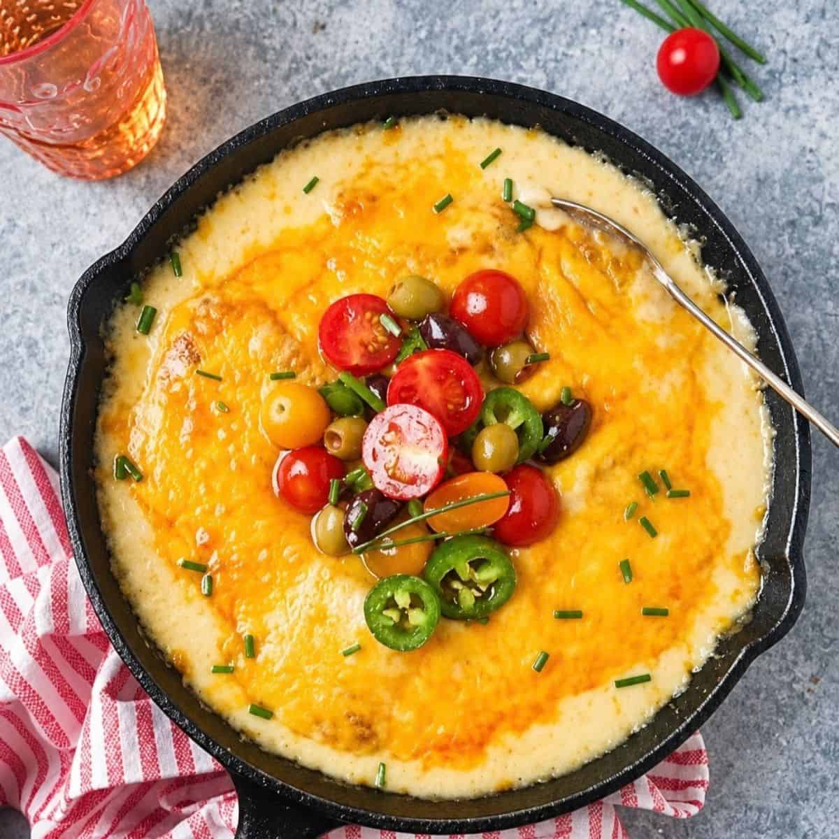 Cheesy cod topped with cherry tomatoes, olives, jalapeño, and chopped chives.