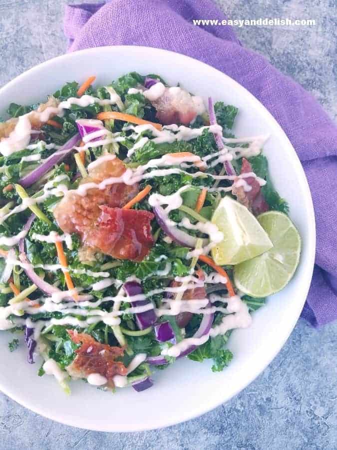 A bowl of homemade coleslaw topped with mayo-based dressing