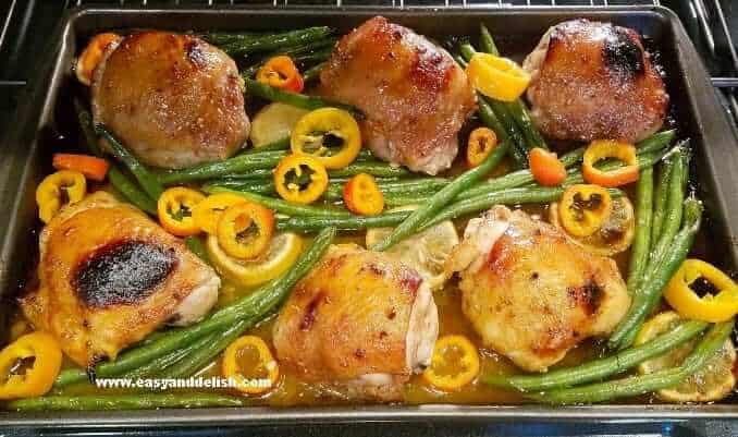 A sheet pan with honey mustard chicken and vegetables.