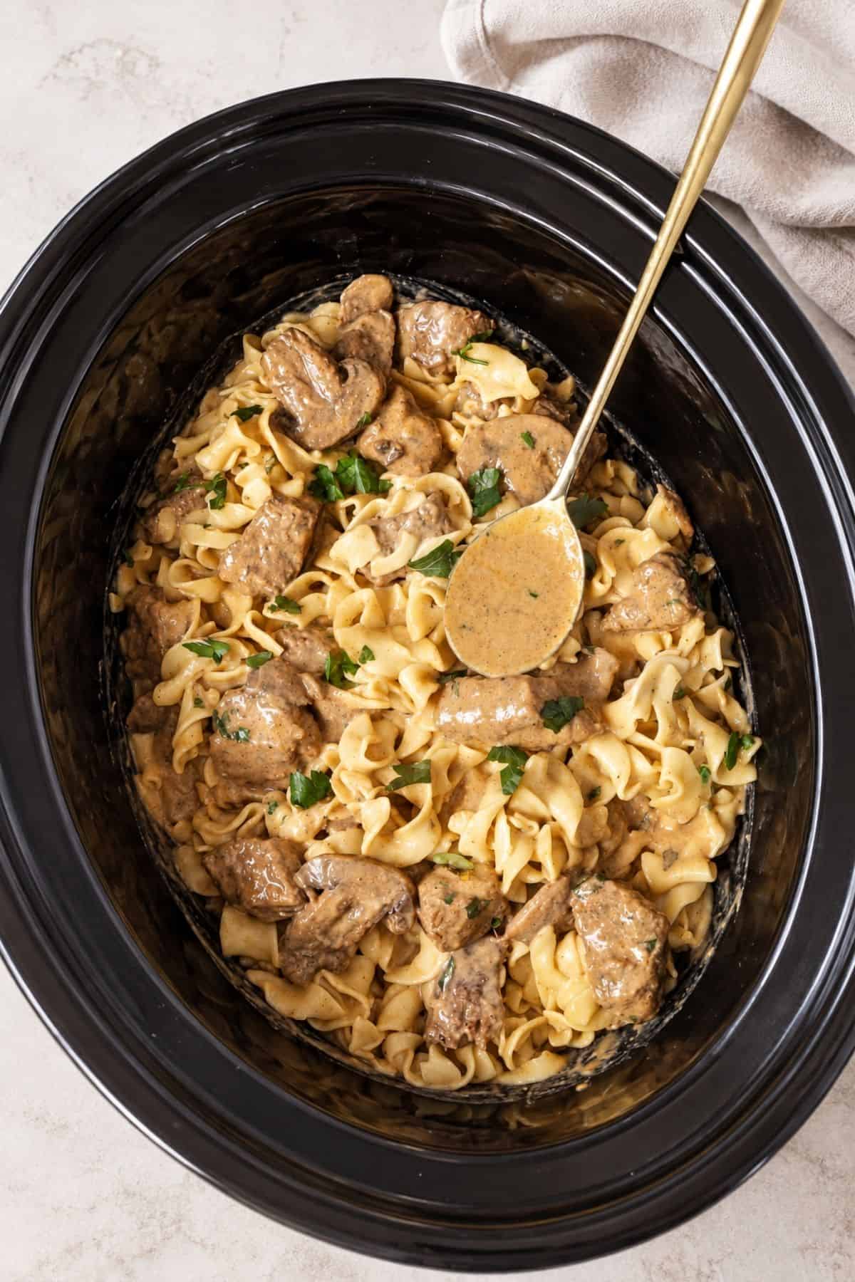 Slow Cooker Beef Stroganoff with tender beef, sliced mushrooms, egg noodles, and parsley in a creamy sauce.