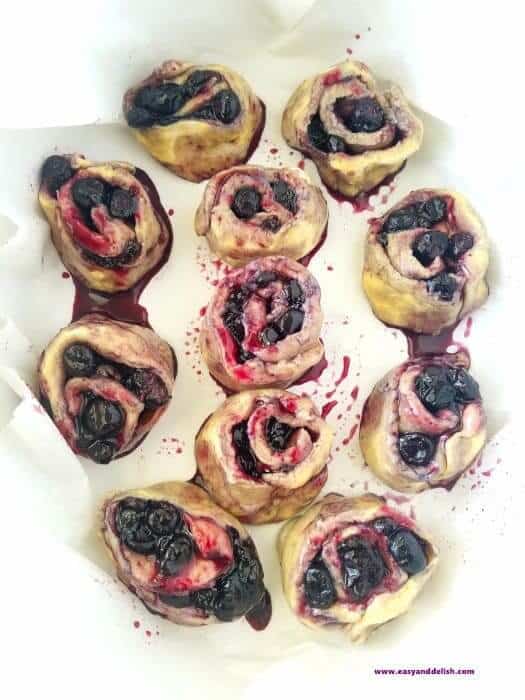 blueberry pie cinnamon rolls arranged in a baking pan before baking 