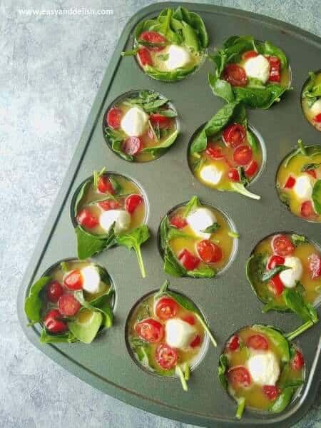 filling muffin tin to bake Caprese breakfast egg cups