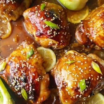 A close up of honey soy chicken with lemon slices