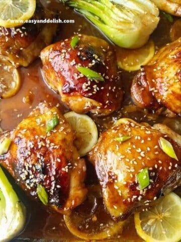 A close up of honey soy chicken with lemon slices