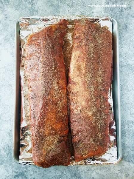 2 long ribs topped with dry rub on a baking pan