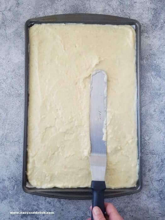 spreading potato roulade batter in a baking sheet