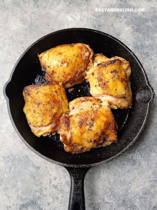 chicken thighs being cooked in a pan