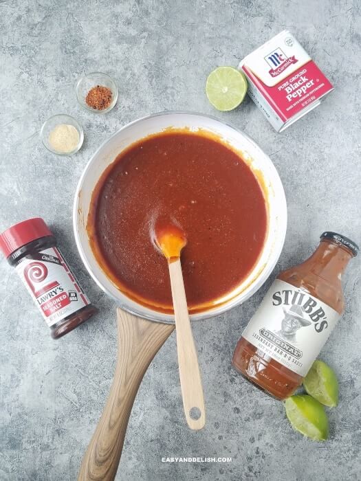 cooking barbecue sauce with seasonings and lime on the side