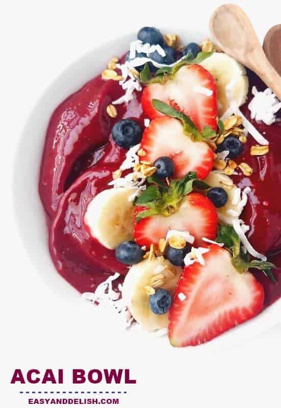 close up of acai bowl with coconut flakes, sliced bananas, and berries 