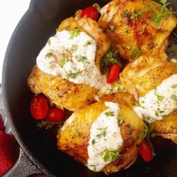 A pan with ranch chicken thighs with sauce on top