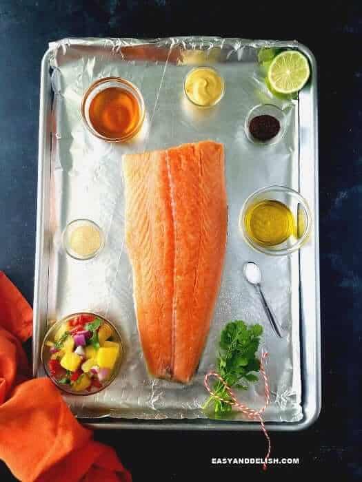 salmon fillet and other ingredients in a cookie sheet