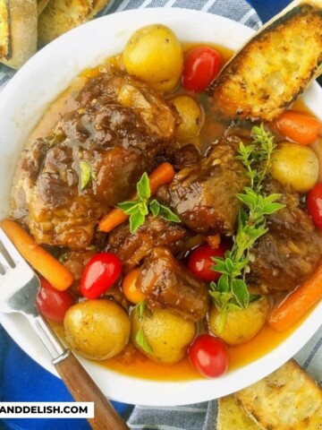 close up of a bowl of beef oxtail with veggies and toast