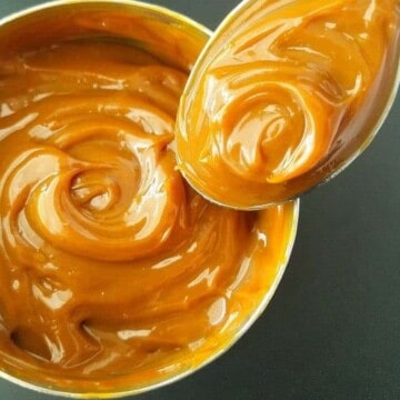 a can of homemade dulce de leche with a spoon