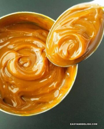 a can of homemade dulce de leche with a spoon
