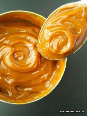 a can of homemade dulce de leche with a spoon