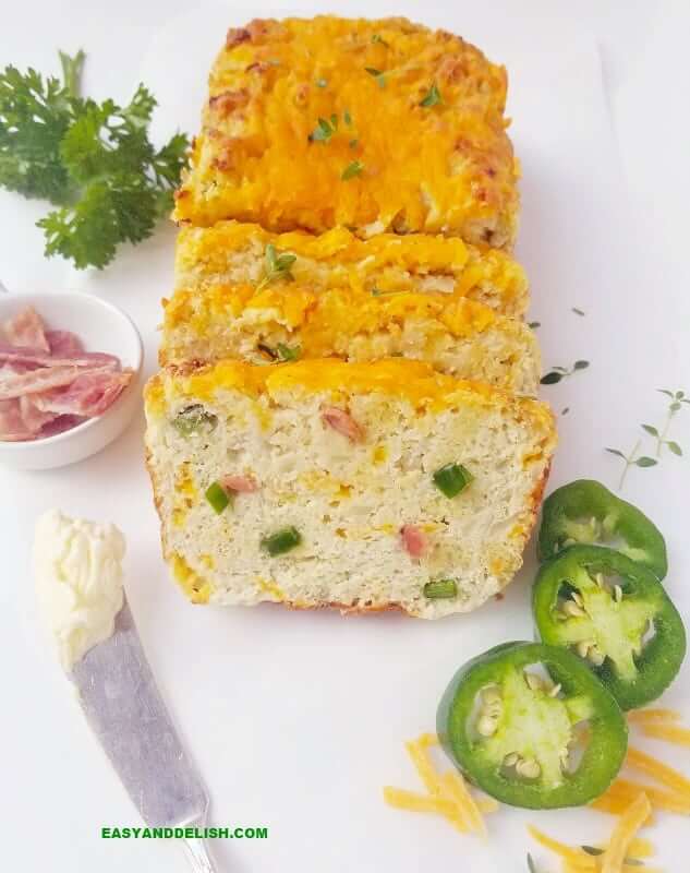 partially sliced cauliflower bread with garnishing on the side