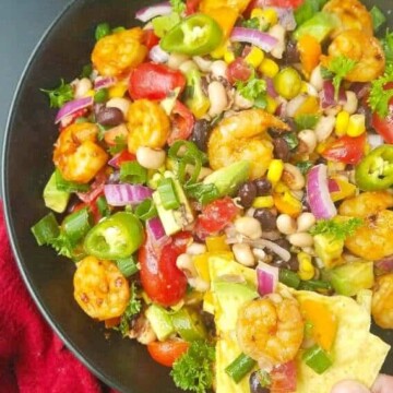 texas caviar recipe in a skillet with shrimp, avocado, and lime vinaigrette with tortilla chips.