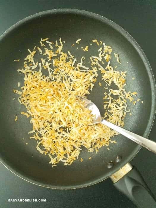 toasting coconut flakes in a skillet