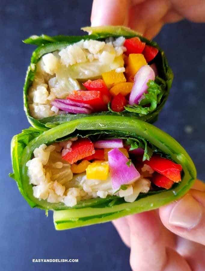 close up image showing 2 collard green wraps being held