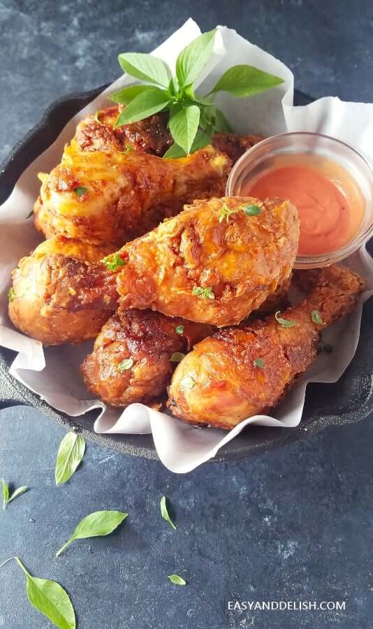fried chicken served in a pan with sauce on the side