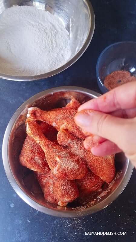 seasoning chicken with salt and spices 