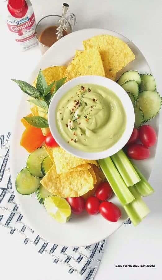 creamy avocado dip served with veggies and tortilla chips