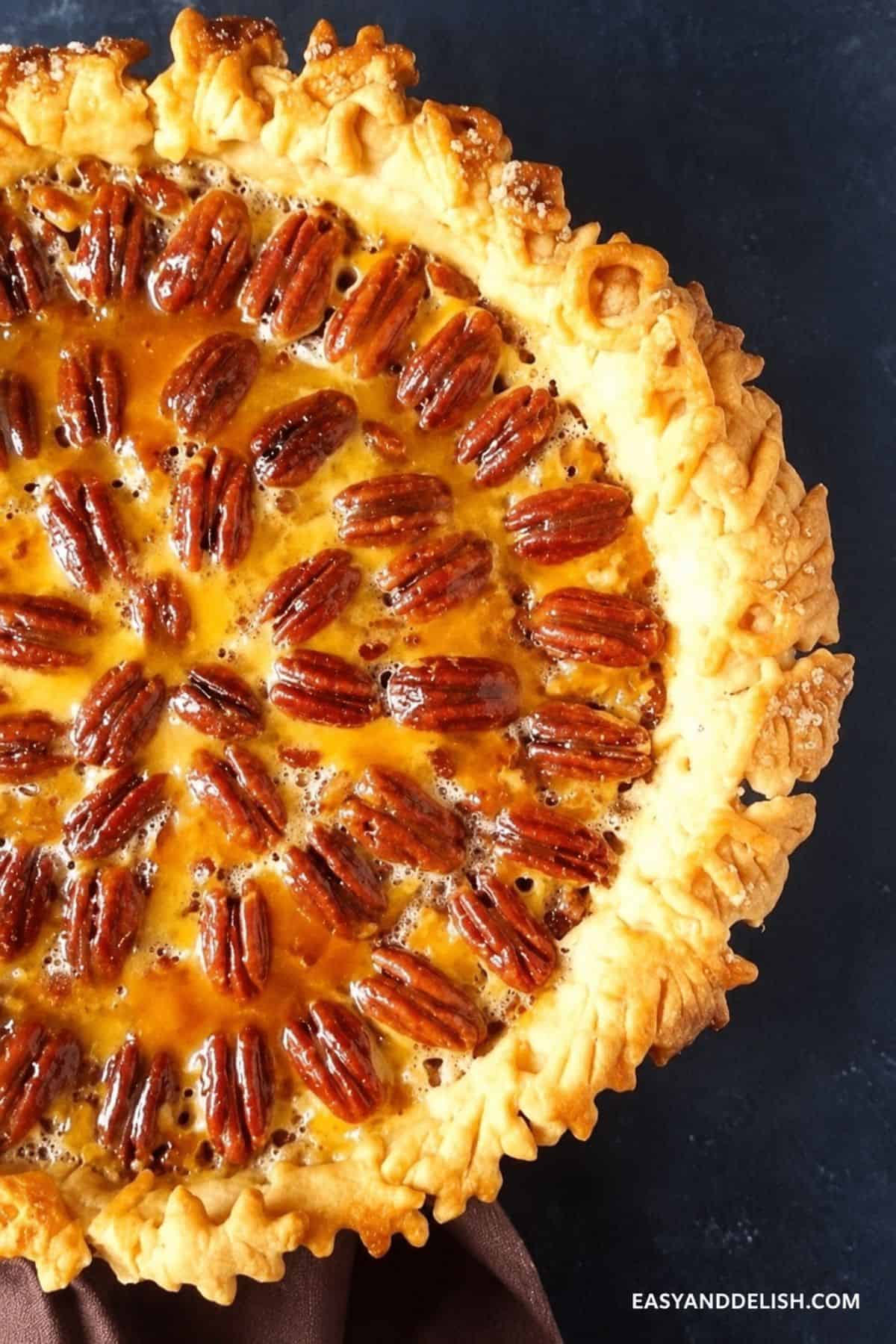 Baked pecan pie topped with glossy whole pecans and a golden crust.