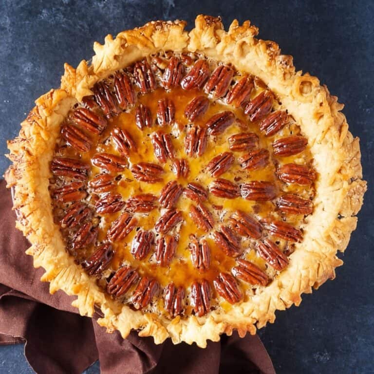 Texas pecan pie with a golden decorative crust and glossy filling.