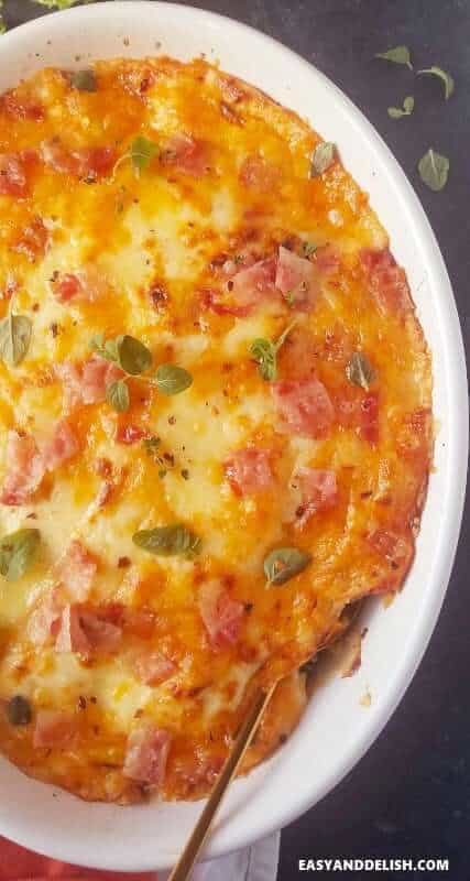 cheesy baked broccoli gratin with bacon in a white dish