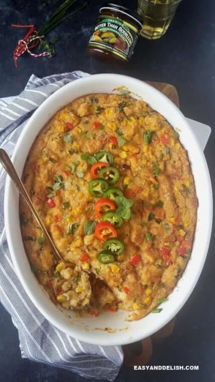 cornbread casserole partially eatem with a glass of juice on the side