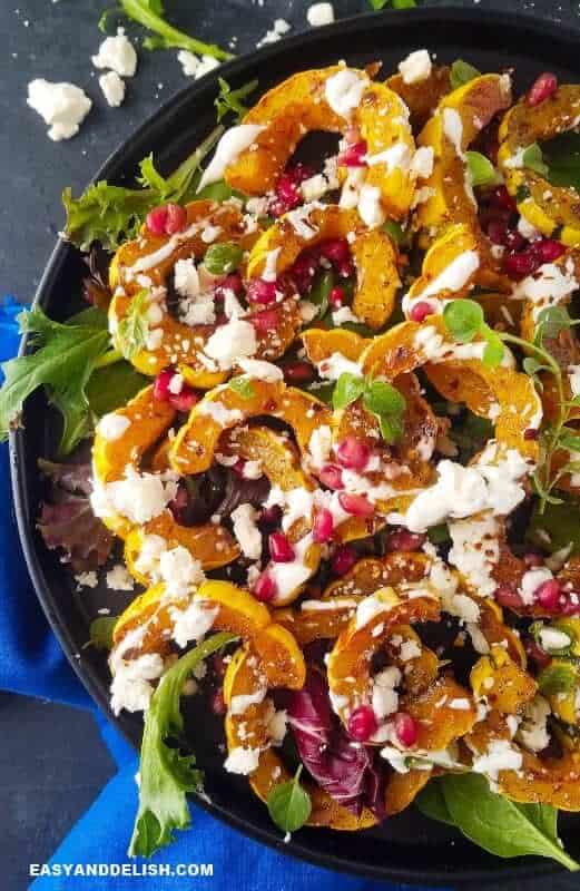 Learn how to cook delicata squash in the oven. It's simple and quick! NO PEELING NEEDED. This roasted delicata squash recipe is vegetarian, low carb, and sugar-free! Simply one of the most comforting ande delicious side dishes ever. #delicatasquash #squash #holidays #thanskgiving #easyrecipe #quickrecipe #roasting #side #lowcarb #vegetarian #sugarfree close up image showing half of a bowl with roasted delicata squash