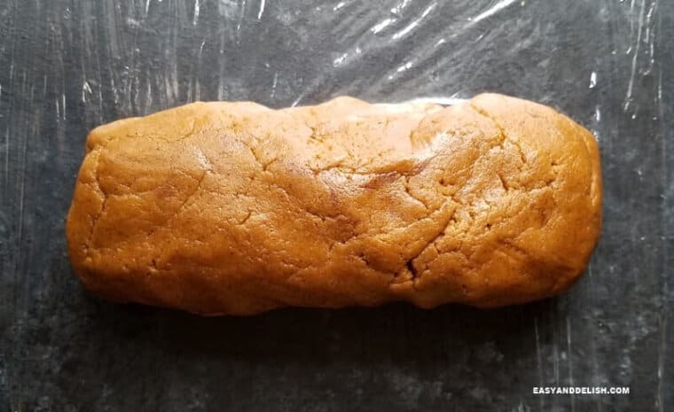 ginger molasses cookie dough over a surface lined with plastic wrap