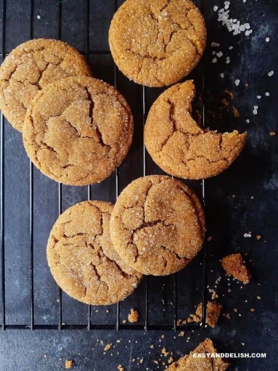 chewy ginger crinkle cookies on a rack with sugar sprinkles othe the side