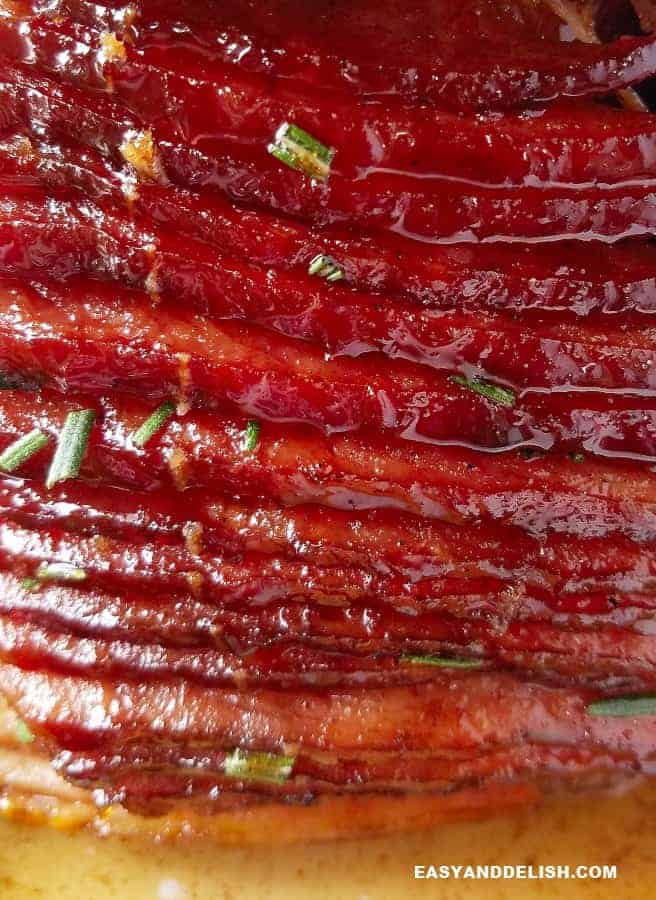This easy Honey Baked Ham recipe is the best holiday ham you'll ever have. It is juicy, tender, with a delish caramelized honey glaze. It's pure FOODPORN! close up of sliced honey baked ham facing down
