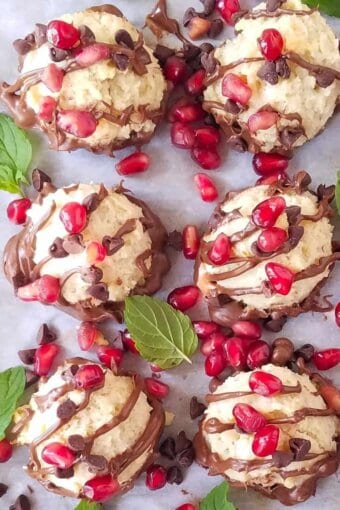 close up of several  low carb chocolate chip coconut cookies with pomegranate seeds